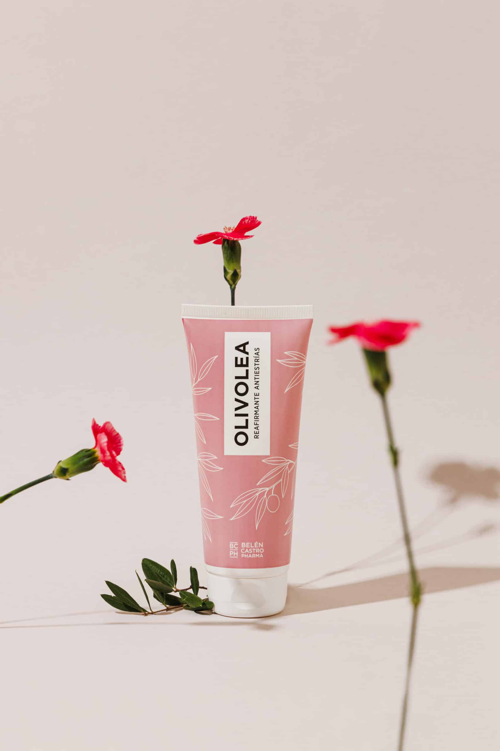 Bote rosa con decorado de hojas blancas, crema reafirmante antiestrías de Olivolea con flores alrededor